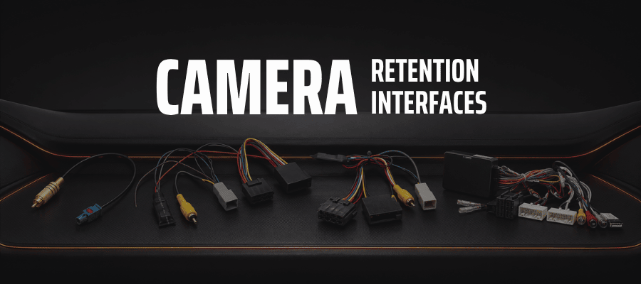 Vehicle-specific factory reversing camera retention cables and interfaces for aftermarket car stereos